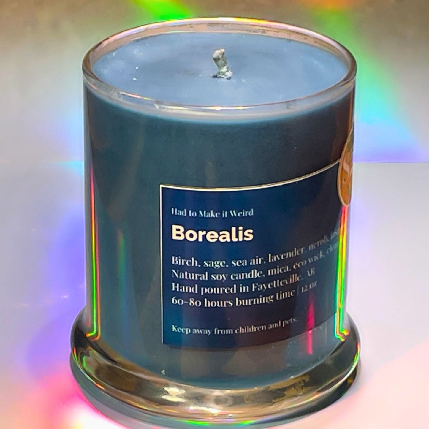 Candle with a label titled 'Borealis' on a colorful gradient background